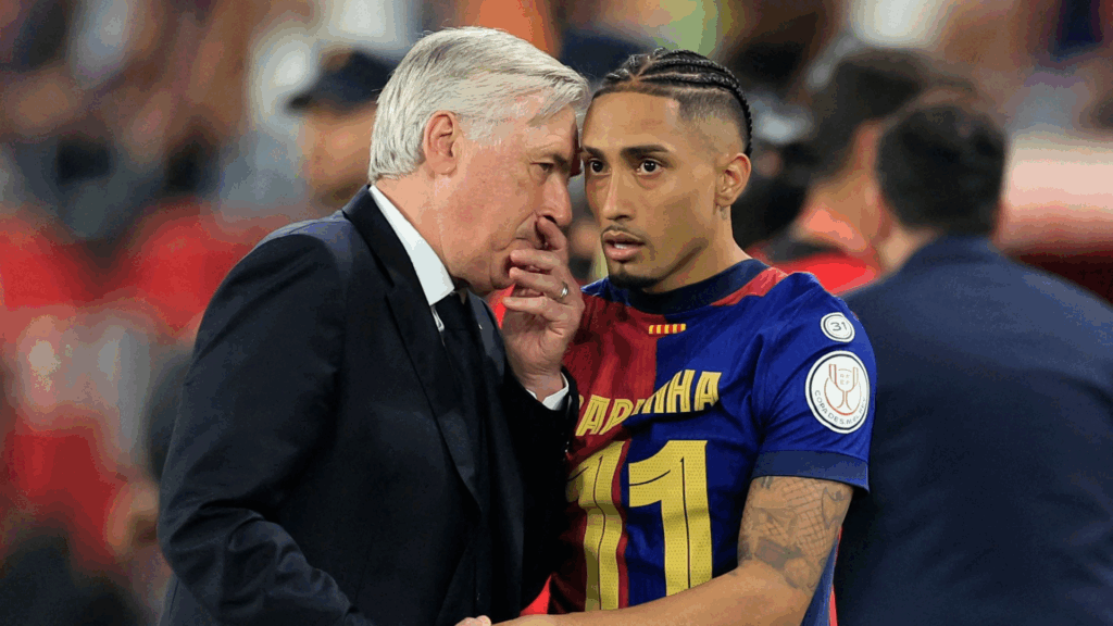 Carlos Ancelotti conversando com um jogador durante um jogo de futebol, ambos em uniformes de suas equipes.